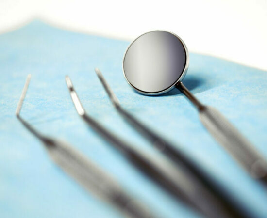 Close up view of dentist tools against blue background